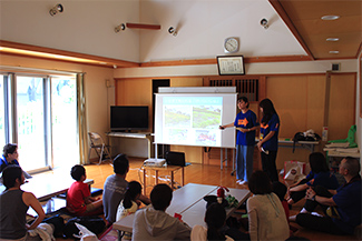 まずは、稲城市の自然および外来生物に関する講義を実施。当初は市職員が話をしたが、平成29年度からは駒沢女子大学アクティ部の学生たちが講師役を担っている。