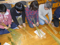 農園で収穫した稲藁を用いた正月飾りづくり体験（2014年12月10日）。この講座で学んだことを、翌週の小学校での授業支援に活かすのも目的の一つとして実施。