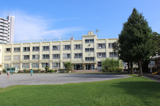 青空に生える芝生の校庭が特徴的な中野区立中野本郷小学校。