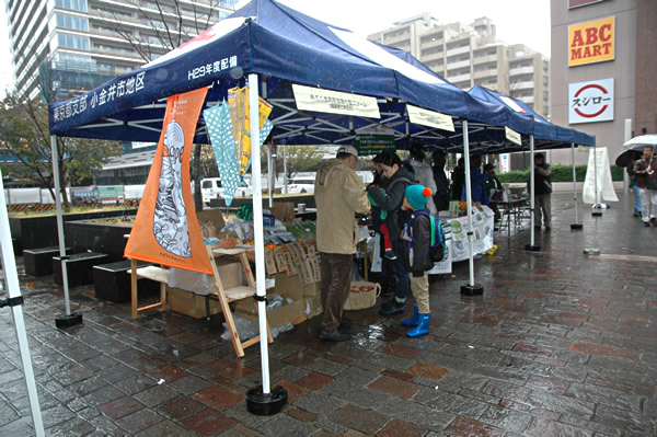 JR武蔵小金井駅南口コミュニティ広場で開催された「こがねい環境フォーラム2019」。あいにくの雨にも負けずブースを展開する関係者からは、一人でも多くの市民に環境・防災に関心をもってほしいという熱意が感じられた。