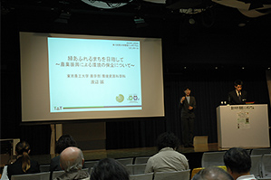 基調講演に登壇した渡辺誠准教授（右）。隣は手話通訳者。