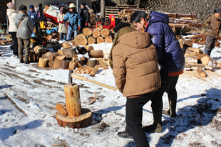 斧を使った薪割りに汗する参加者たち（平成27年1月に開催された薪づくり体験イベントより）