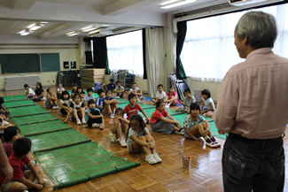 井荻小学校・特活室の教室で、ヤゴフロート製作の説明をする境原さん