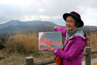 割れ目噴火の写真を掲げて説明するガイドの西谷香奈さん。