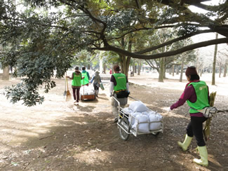 堆肥班の人たちが袋に詰めた落ち葉堆肥を抱えて戻ってくる。（レンジャーズ・プロジェクト事務局提供）