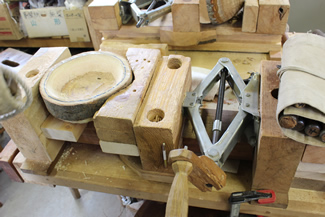 材料の木材を固定しているのは、車のジャッキを利用して自作したクランプ。木槌も枝を使って自作している。