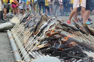 竹串に刺した魚がずらりと並ぶ光景は壮観だ。炭火から放射される熱は予想以上に熱く、近寄れないと顔をしかめる子もいる。