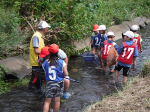 環境診断士や環境学習リーダー、環境市民会議など、63名の環境教育支援者（黄色い服）が、各学校の環境教育実習で川の体験学習や課題別学習の実施を支えてきました。（写真提供：エコひろば）